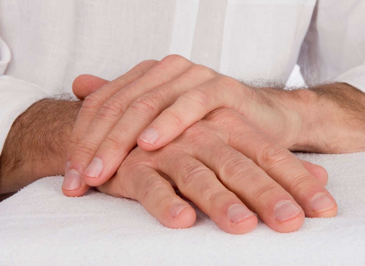 Achtsame Berührung zweier Hände bei einer Massage